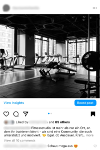Das Bild, das das Innere eines Fitnessstudios zeigt, ist ein Beispiel für einen Social-Media-Post auf Instagram. Es präsentiert ein monochromes Foto des Studios mit einem Text, der die Gemeinschaft und Motivation betont, die das Studio seinen Mitgliedern bietet.
